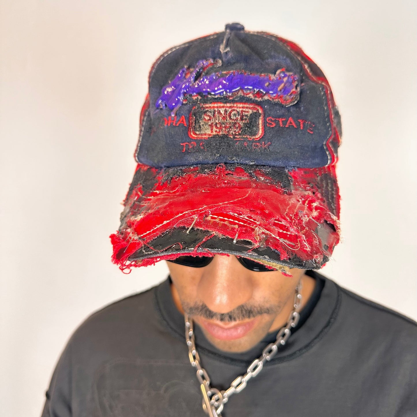 Front of of Blue and red ASTROBOI* hat featuring a purple resin-coated Hawaii graphic, deconstructed visor with clear resin, and black painted accents.