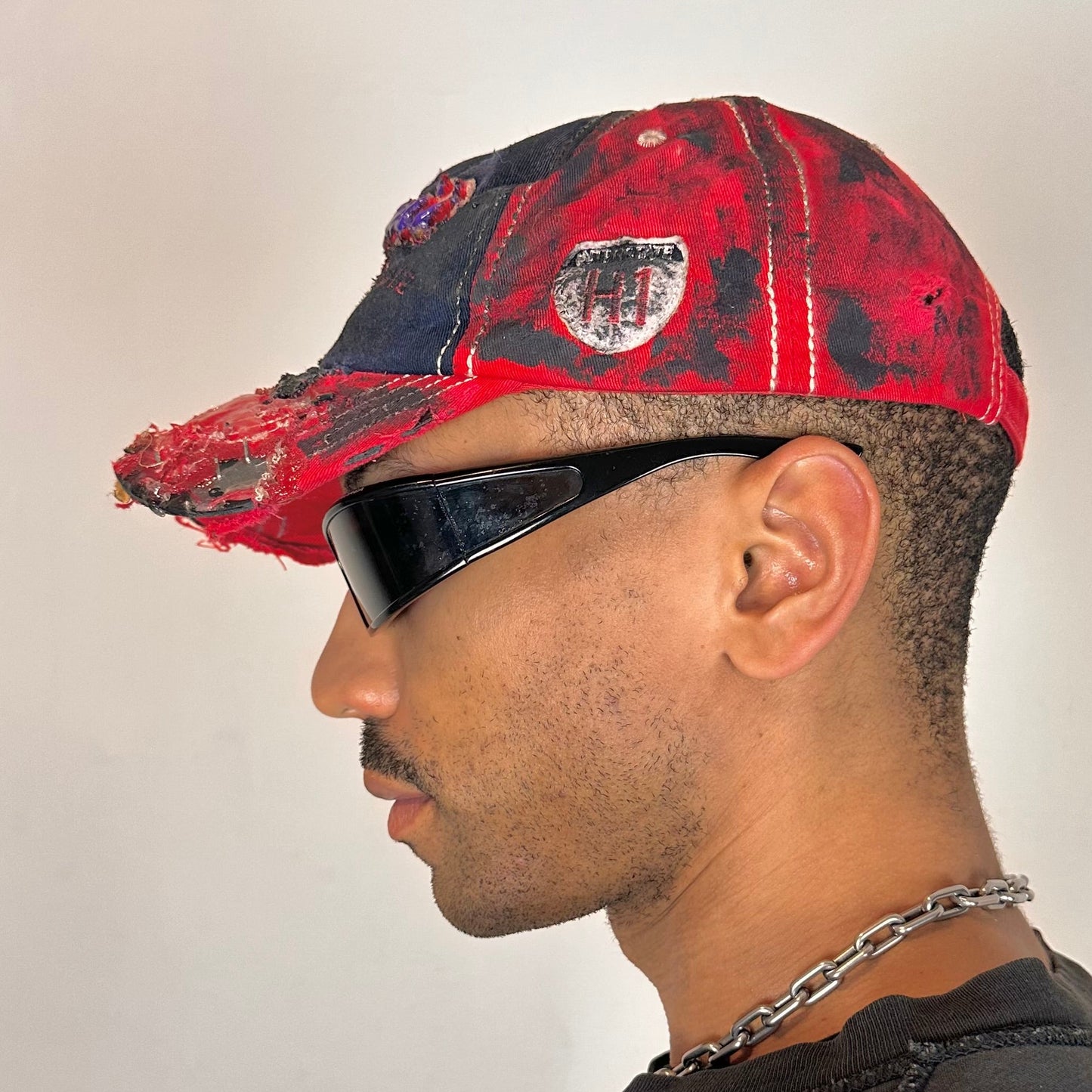 Left side of Blue and red ASTROBOI* hat featuring a purple resin-coated Hawaii graphic, deconstructed visor with clear resin, and black painted accents.