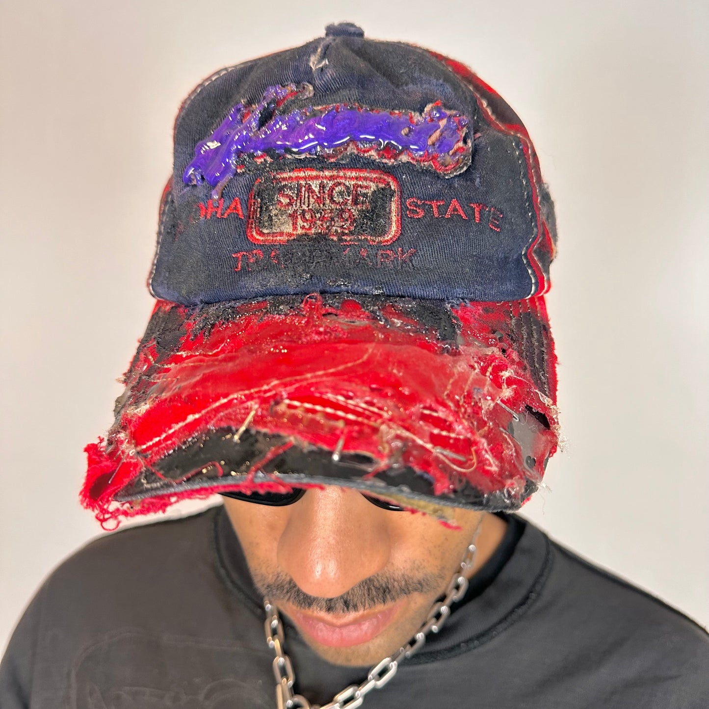 Front close up of of Blue and red ASTROBOI* hat featuring a purple resin-coated Hawaii graphic, deconstructed visor with clear resin, and black painted accents.