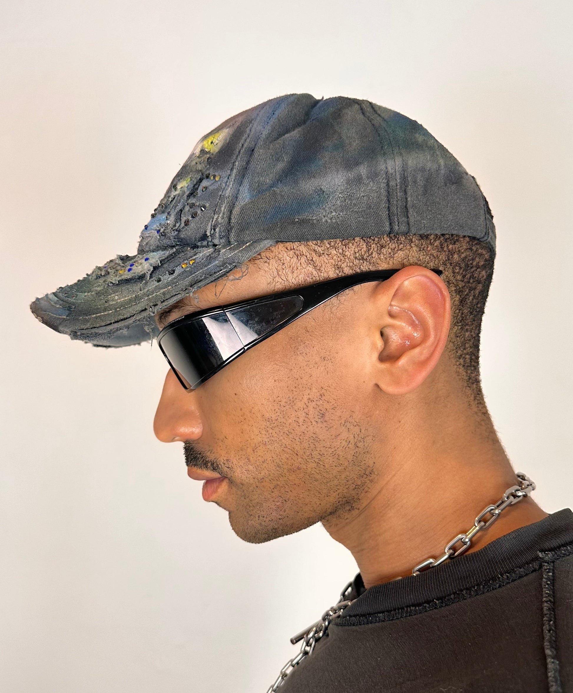 Left side of ASTROBOI* blue rainbow tropical Y2K hat with multicolored rhinestones, hand-painted shading, and adjustable strap back