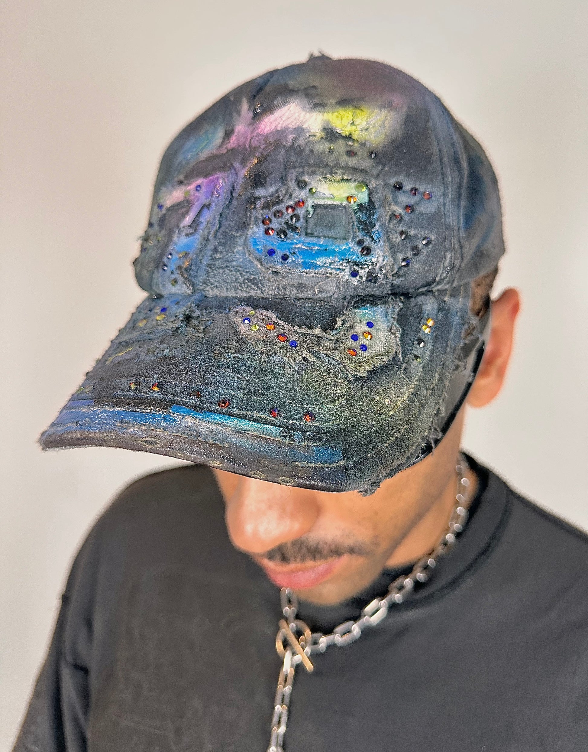 Front left of ASTROBOI* blue rainbow tropical Y2K hat with multicolored rhinestones, hand-painted shading, and adjustable strap back