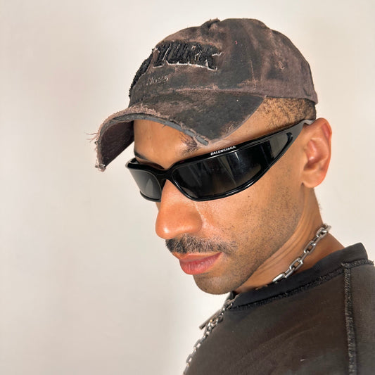 Visor detail on ASTROBOI* New York brown and black distressed half-visor hat with bold logo, black paint accents, and deconstructed grunge design. Handmade in NYC.