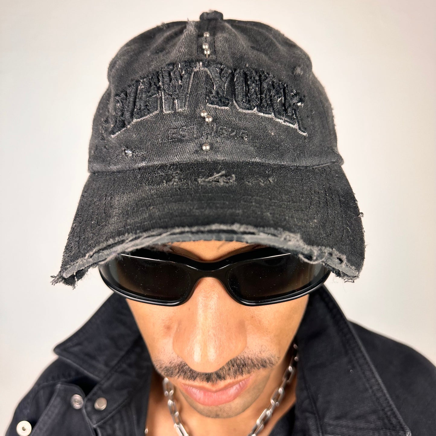Front of ASTROBOI* 'Kinky' New York Black Distressed Pierced Half Visor Hat - flat detail 