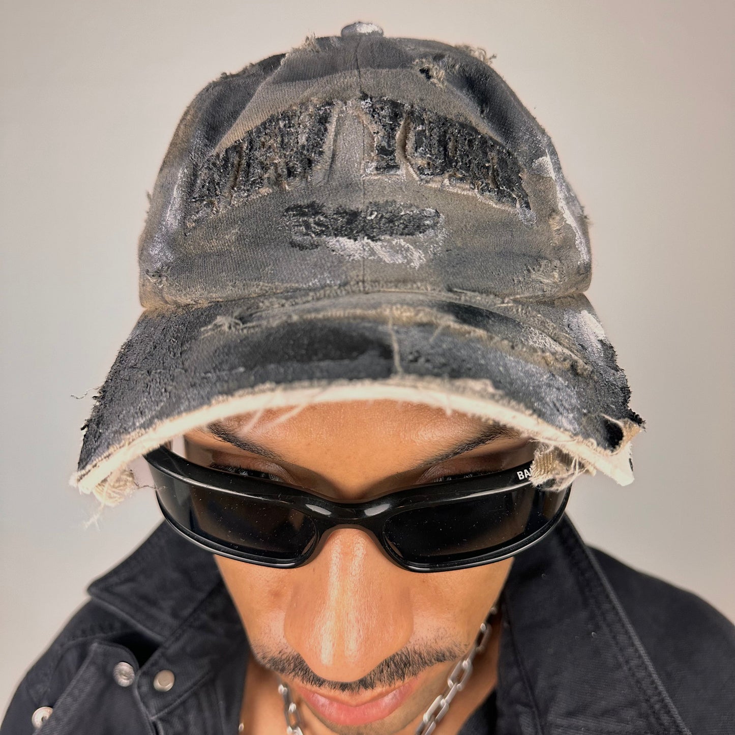 Close up of ASTROBOI* tan and black New York logo hat with distressed half visor and black and white paint detailing.