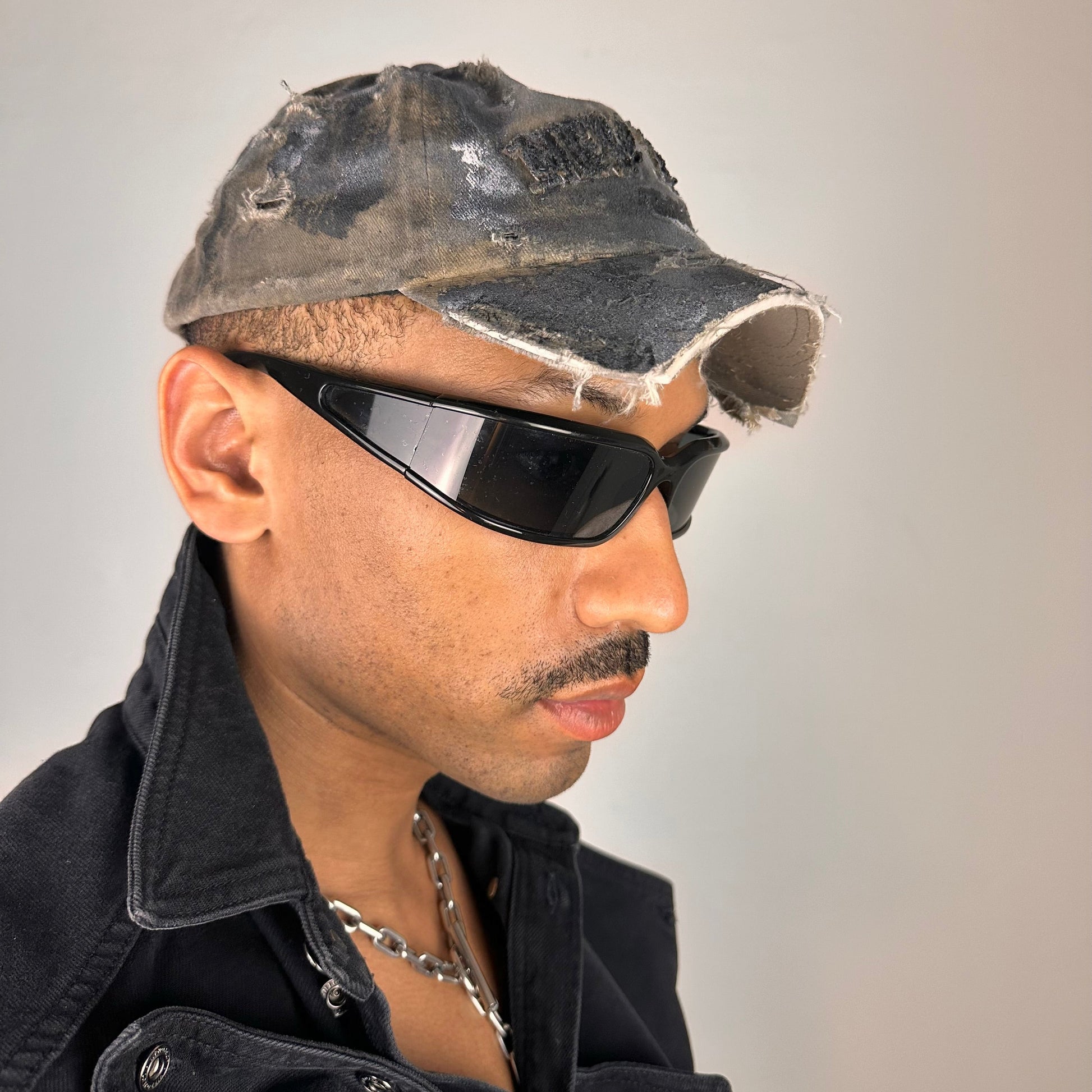 Front right view of ASTROBOI* tan and black New York logo hat with distressed half visor and black and white paint detailing.