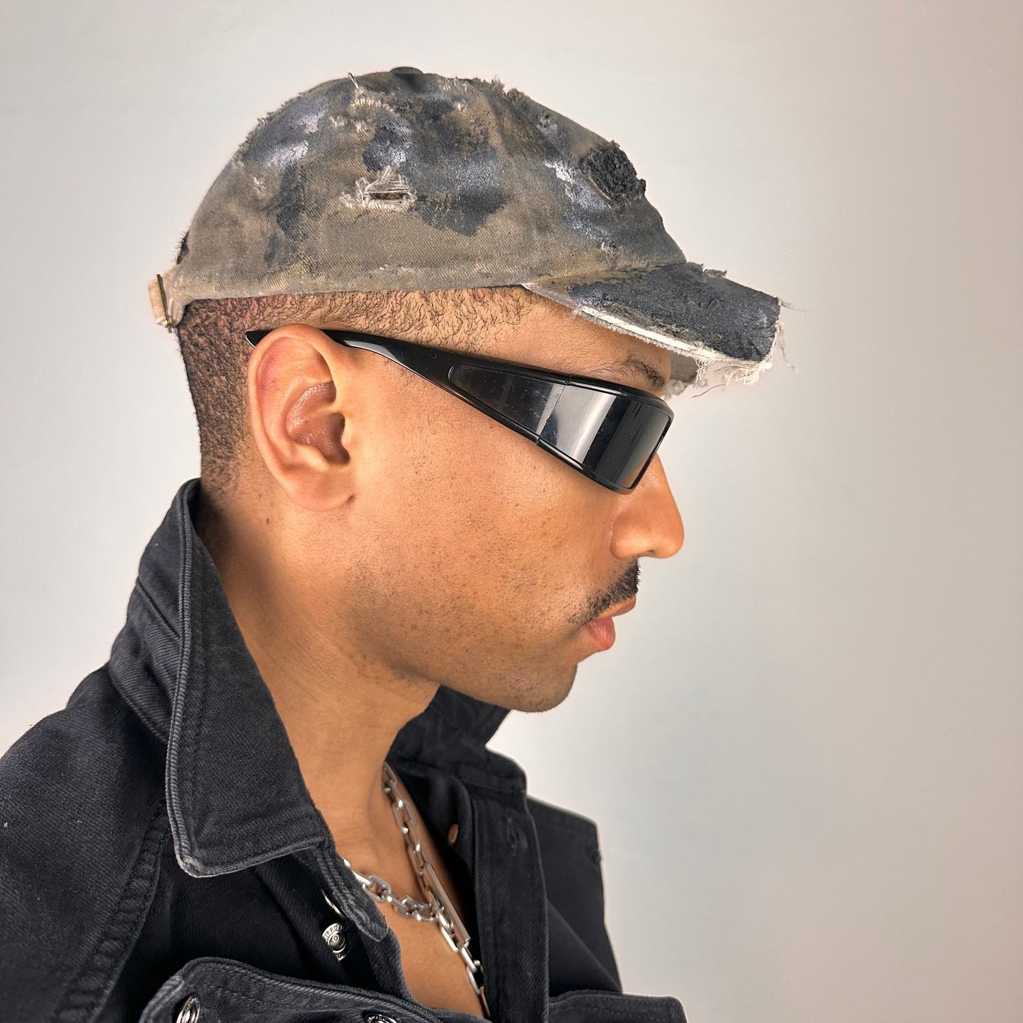 Right side of ASTROBOI* tan and black New York logo hat with distressed half visor and black and white paint detailing.