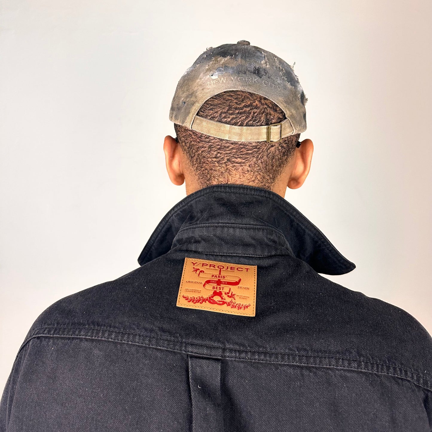 Back of ASTROBOI* tan and black New York logo hat with distressed half visor and black and white paint detailing.