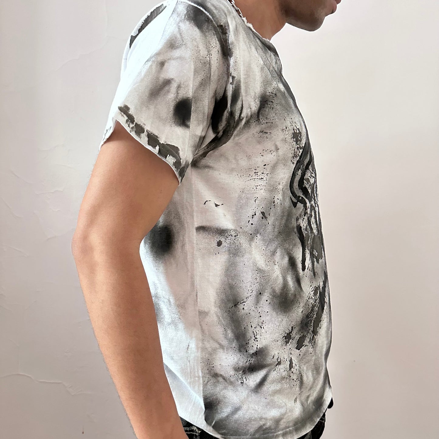  Right side detail of ASTROBOI* x Gildan 'Slither' showing black and gray hazy splatter design on loose-fitting white heavyweight cotton base.