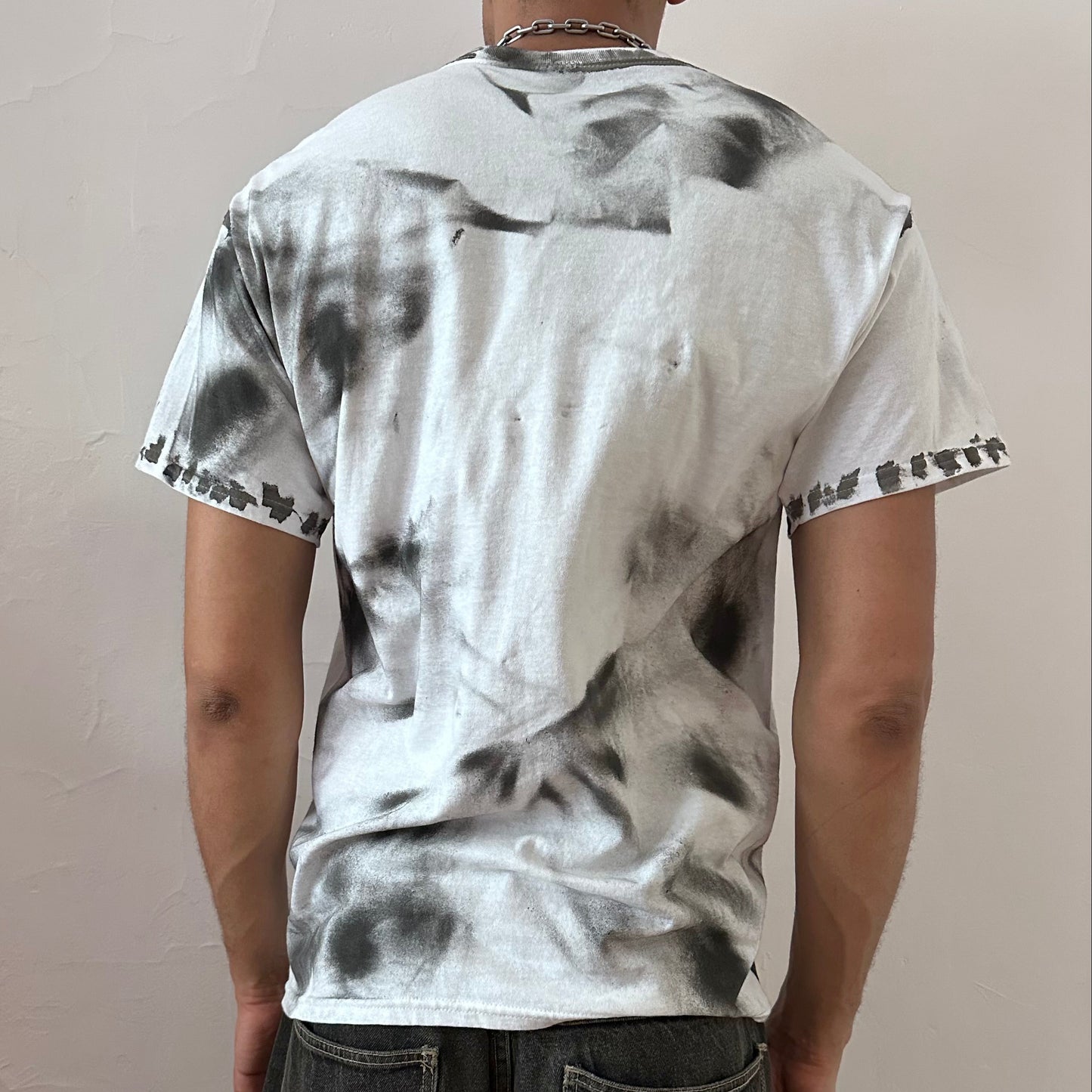 ASTROBOI* x Gildan 'Slither' white and black painted graphic t-shirt, rear view showing hazy splatter paint construction, worn by male model.