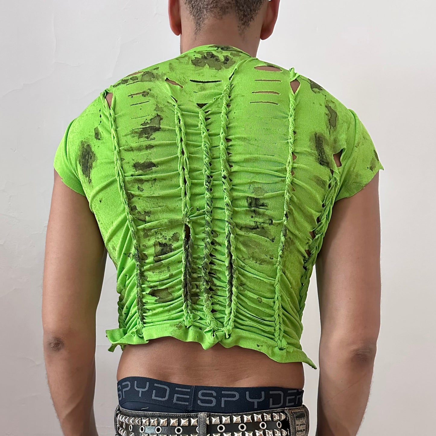ASTROBOI* 'SS26' neon green braided crop t-shirt, rear view showing braid and watercolor paint construction, worn by male model.