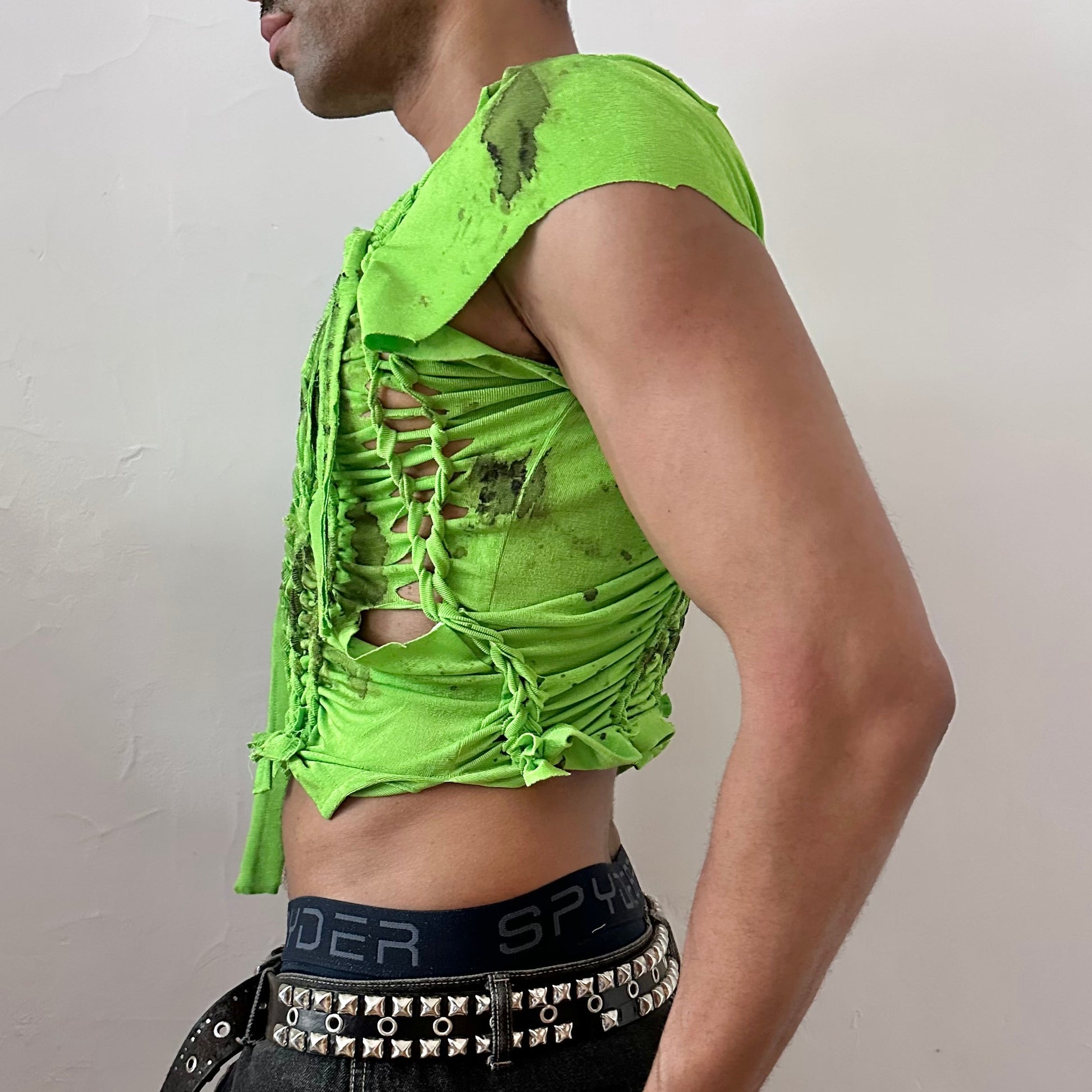 Left side detail of ASTROBOI* 'SS26' showing hand-braided arrangement and black watercolor paint design on cropped neon green stretch tee.