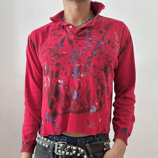 Close-up of ASTROBOI* x Polo Ralph Lauren 'Kill Switch' showing abstract expressionist black, blue, and white paint design and Polo logo detail on red fabric.
