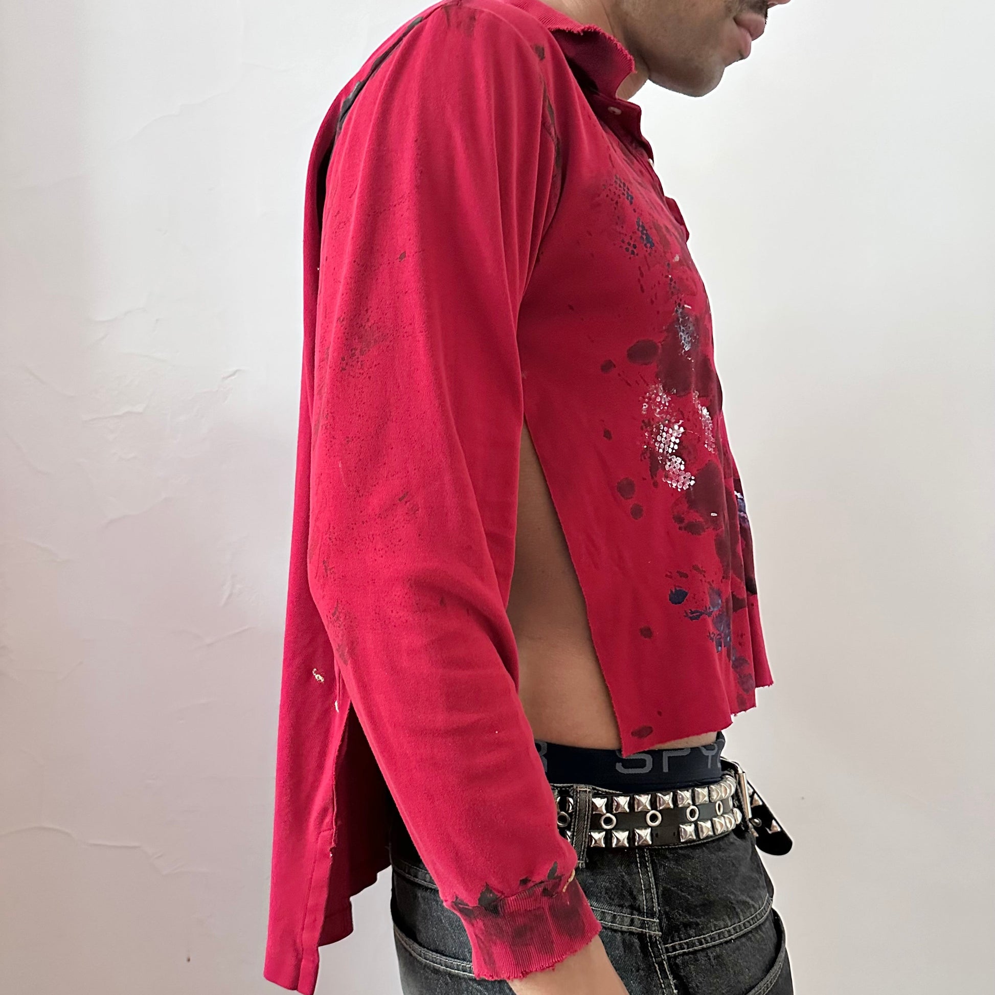  Right side detail of ASTROBOI* x Polo Ralph Lauren 'Kill Switch' showing abstract expressionist paint design and side slit on loose-fitting red base.