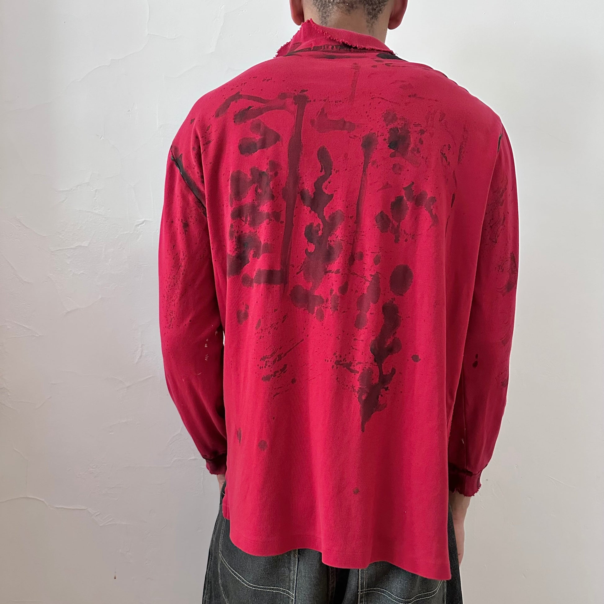 ASTROBOI* x Polo Ralph Lauren 'Kill Switch' red grunge long sleeve festival polo, rear view showing abstract expressionist paint design, worn by male model.