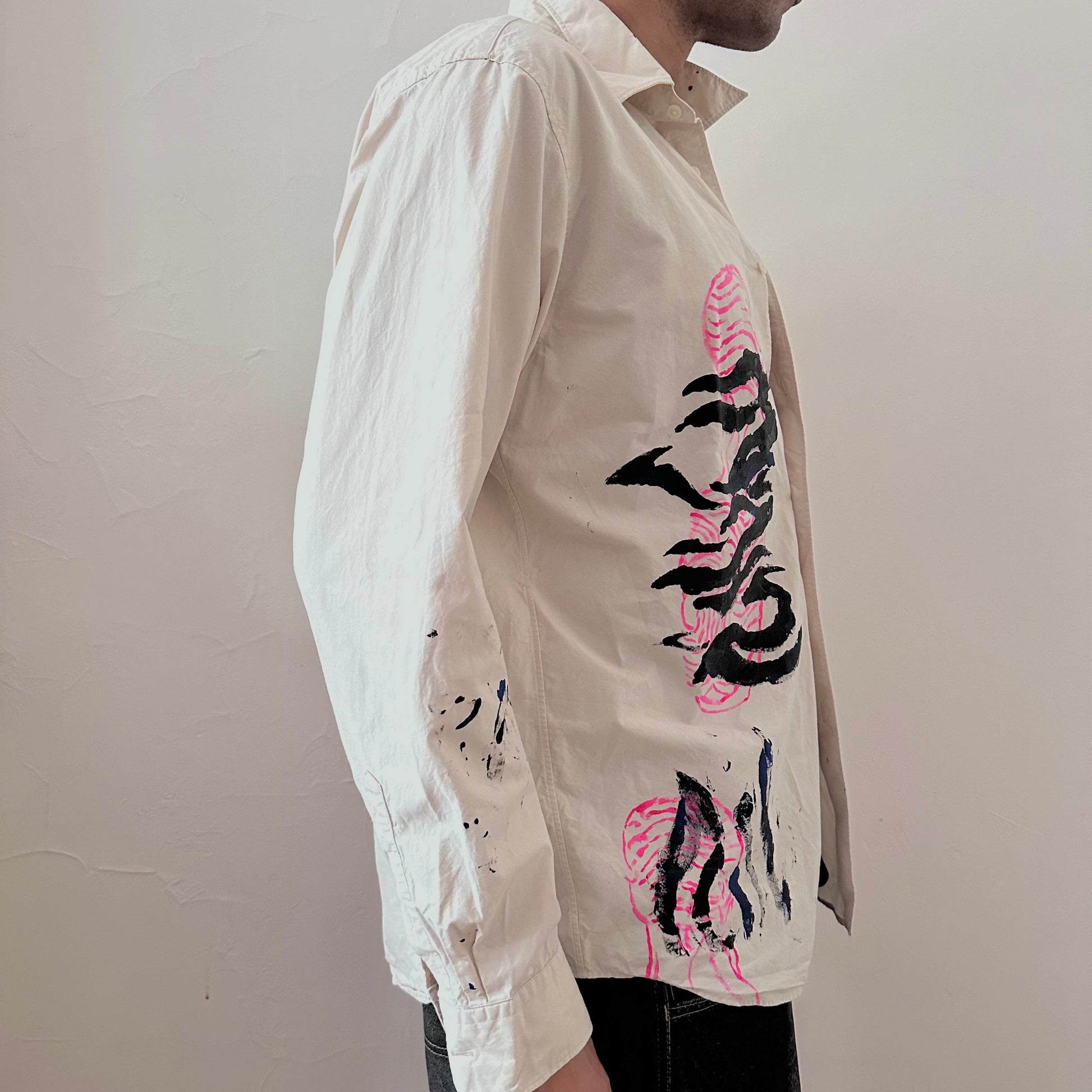 Right side detail of ASTROBOI* x Uniqlo 'Tattoo' showing pink abstract and black expressionist paint overlay on relaxed-fit tan cotton base.