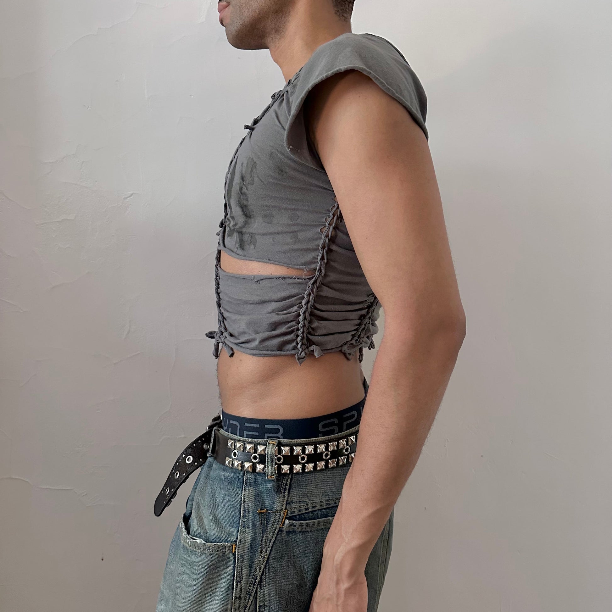 Left side detail of ASTROBOI* 'Waverly' showing hand-braided arrangement, slash detail, and faded tattoo print on gray crop tee.