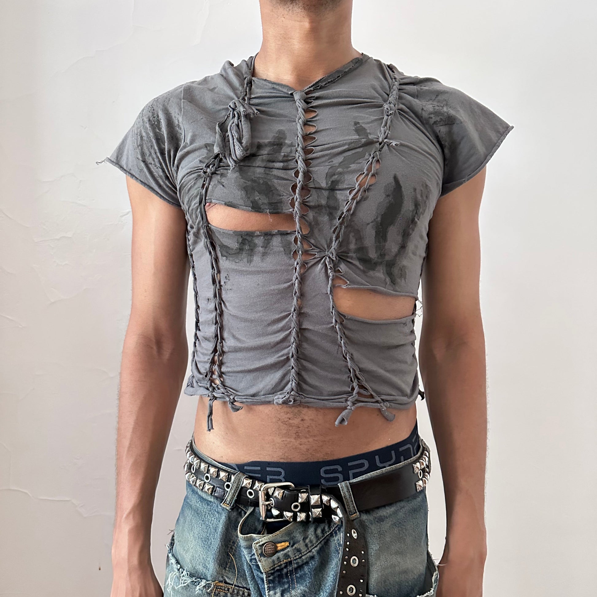 ASTROBOI* 'Waverly' gray form-fitting braided festival crop t-shirt with hand-braided arrangement, slashes, and faded tattoo print on front, front view.