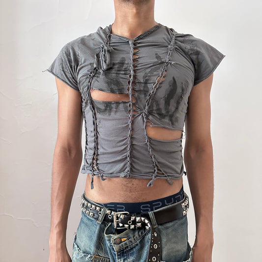 ASTROBOI* 'Waverly' gray form-fitting braided festival crop t-shirt with hand-braided arrangement, slashes, and faded tattoo print on front, front view.