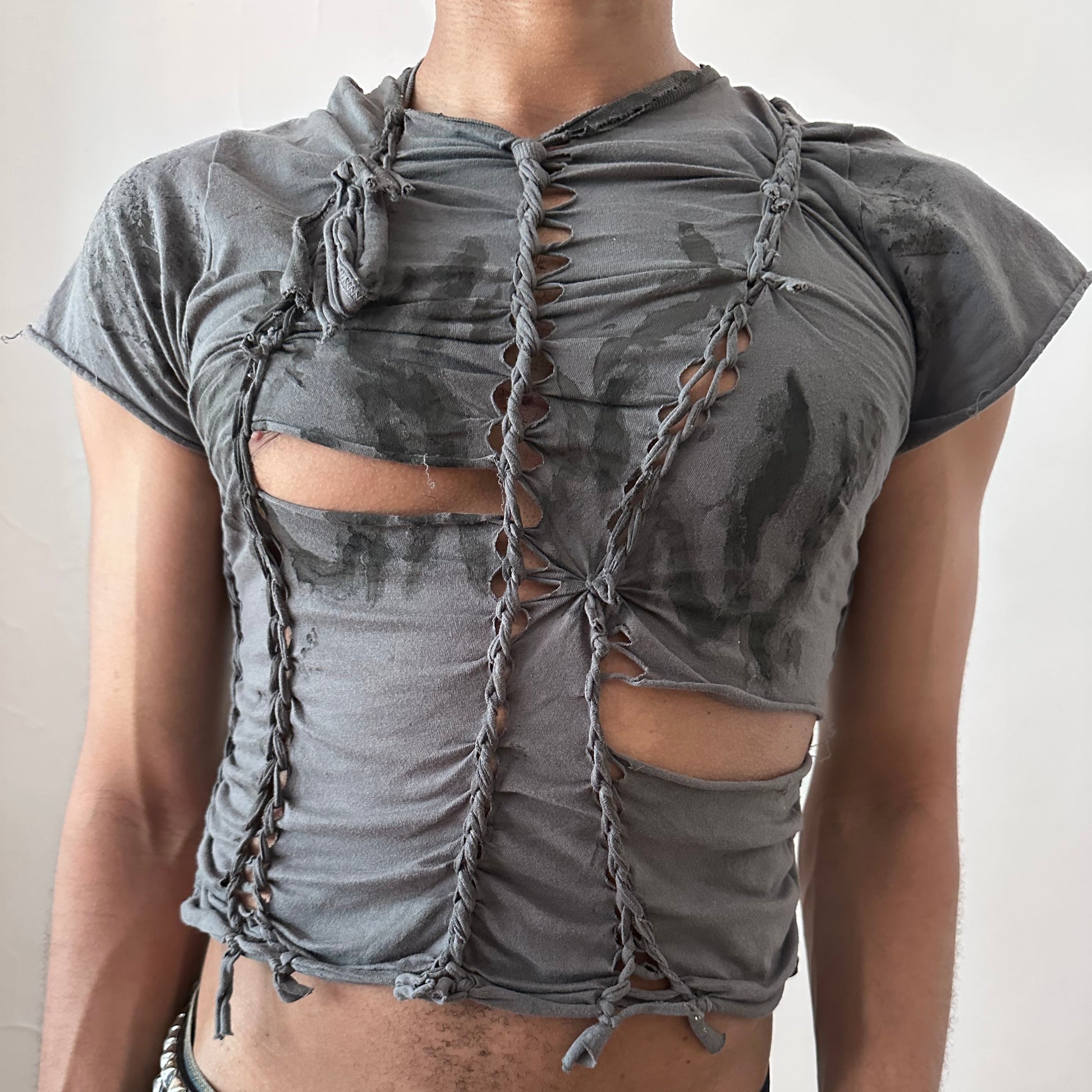 Close-up of ASTROBOI* 'Waverly' showing hand-braided construction, slash detailing, and faded tattoo print on gray fabric.