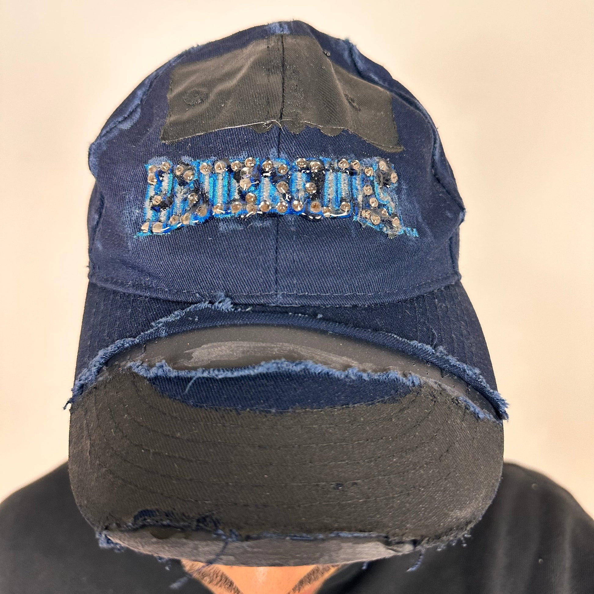 Cover image of ASTROBOI* x Renegades navy distressed hat with resin-sealed rhinestones and tattoo-style paint details. One-of-one custom piece made in NYC.