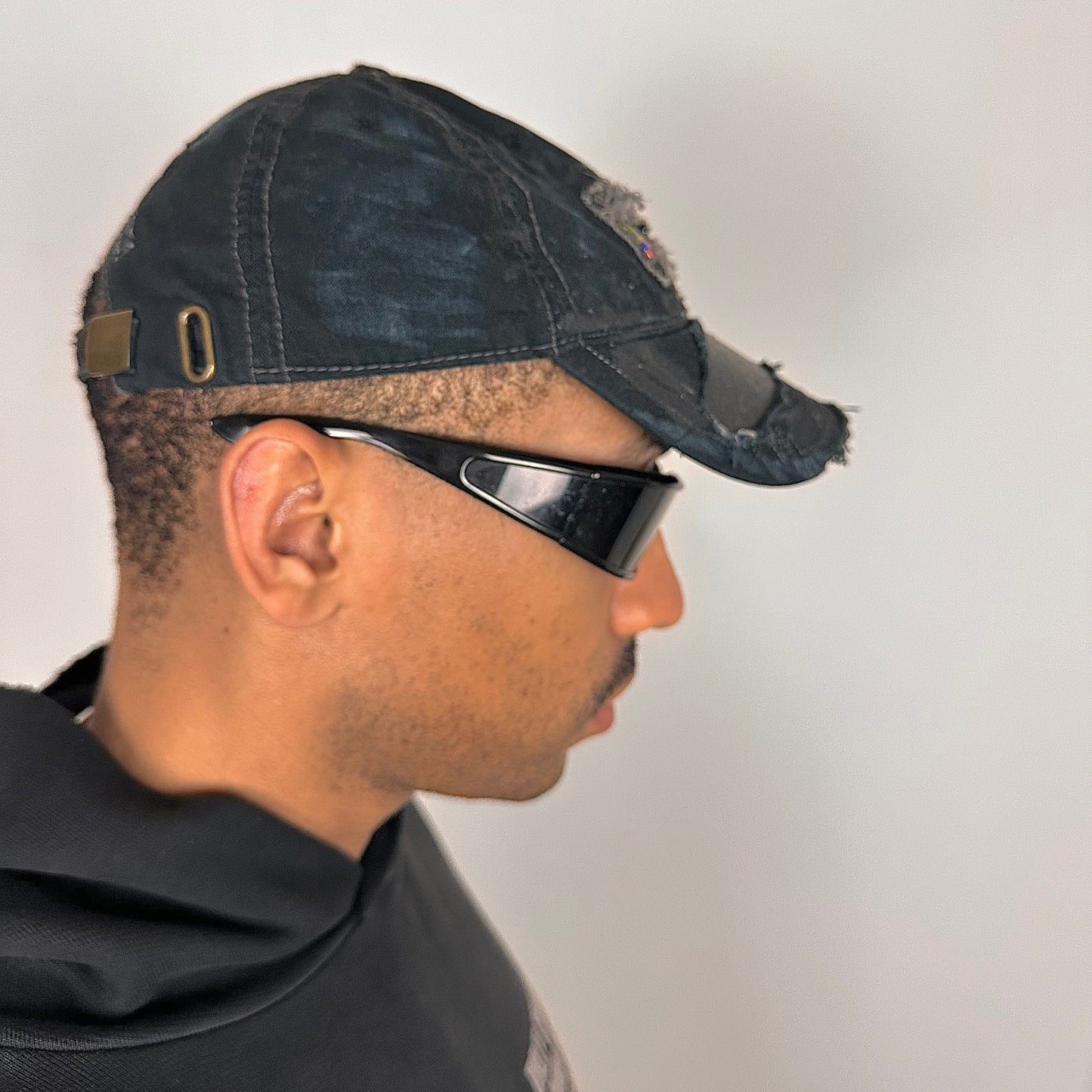 Right side of ASTROBOI* New York Aquarium navy distressed baseball hat with resin-sealed rhinestone logo, black waxed paint details, adjustable strap, custom NYC piece