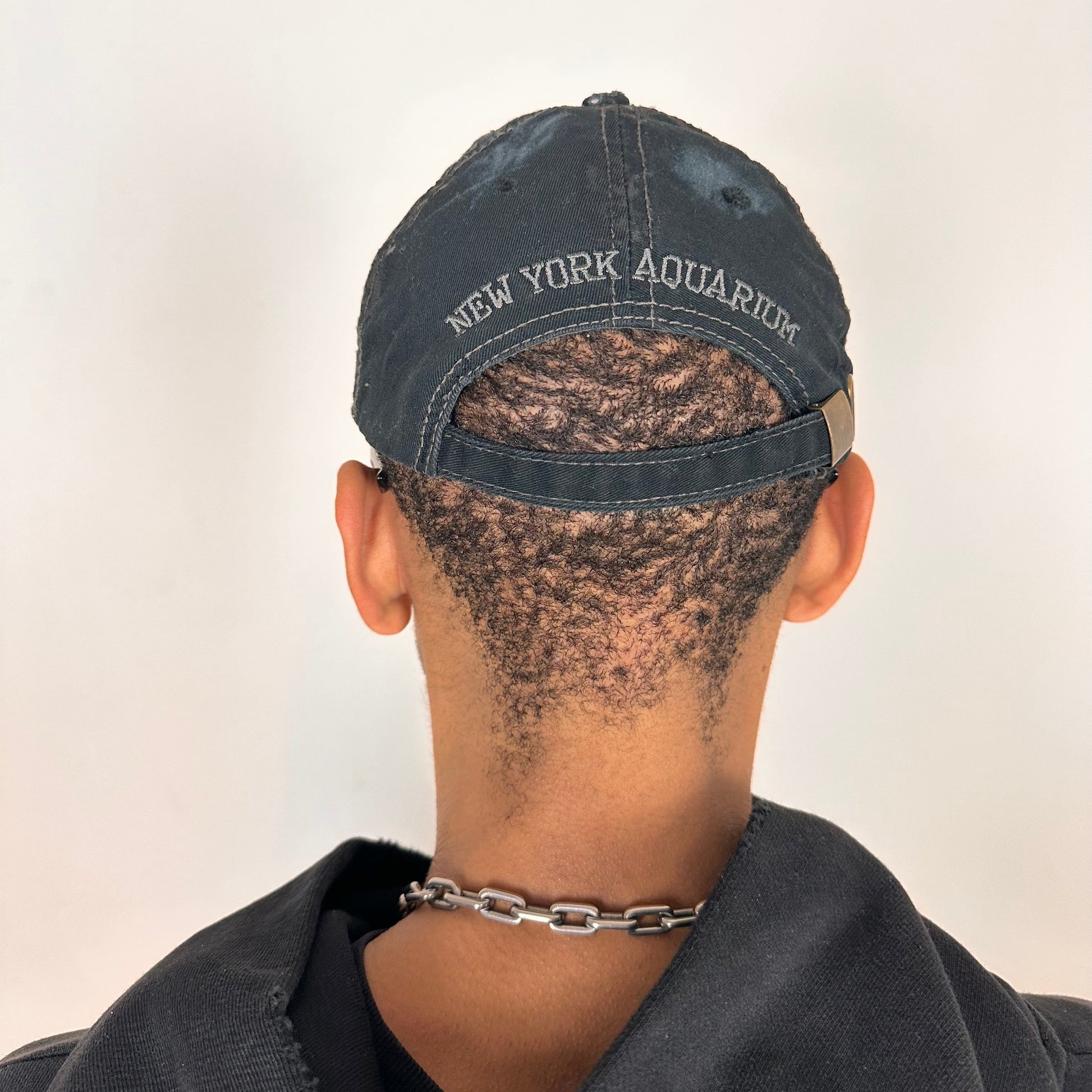 Back of ASTROBOI* New York Aquarium navy distressed baseball hat with resin-sealed rhinestone logo, black waxed paint details, adjustable strap, custom NYC piece