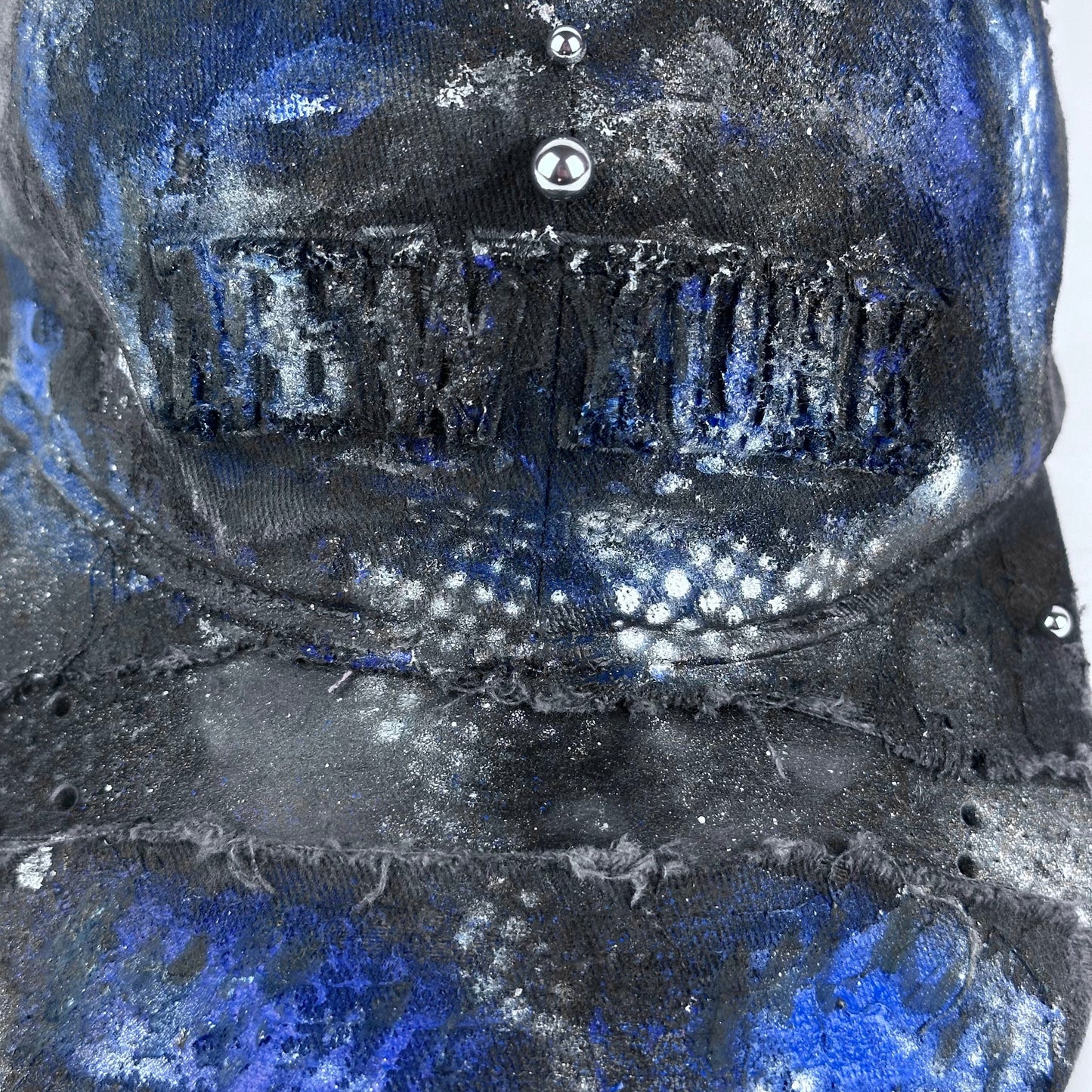Close-up of ASTROBOI* 'North Star' showing "New York" embroidery detail and black, white, and blue distressed paint design.