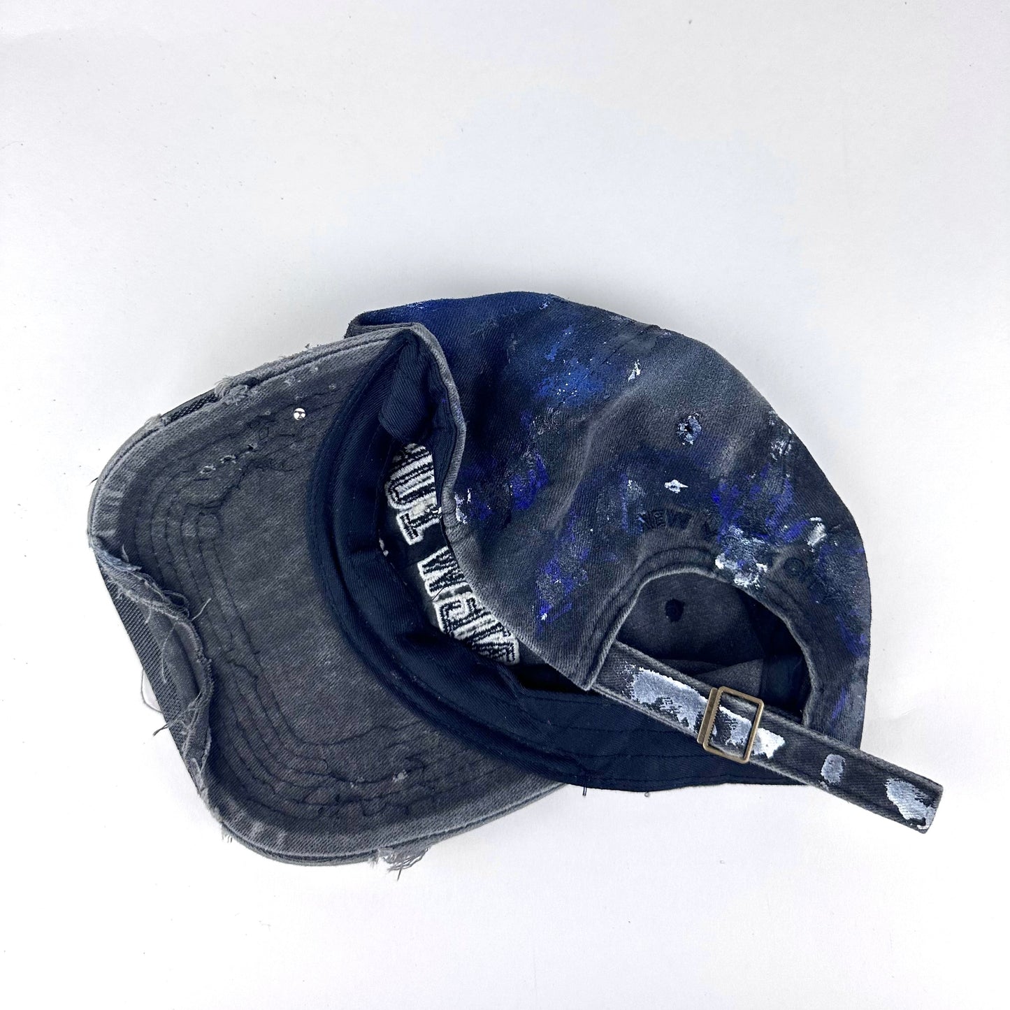 ASTROBOI* 'North Star' black and blue distressed painted hat, rear view showing adjustable strap and distressed finish.