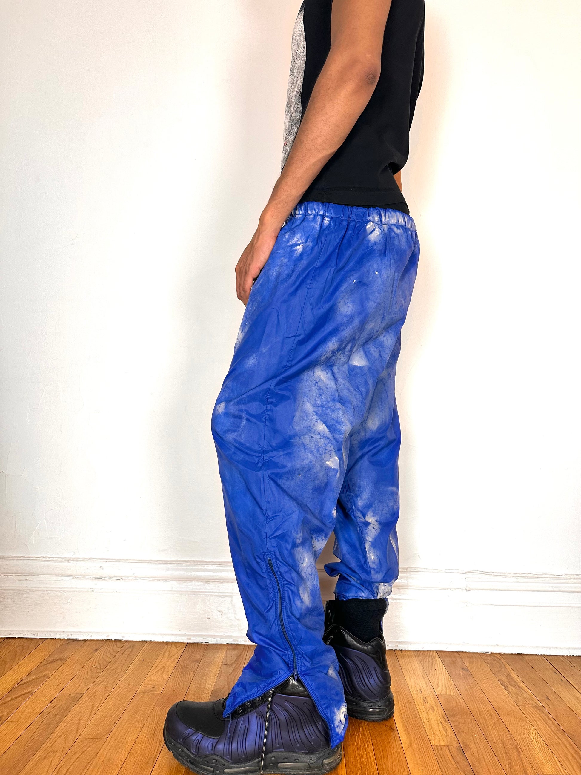 Left side of ASTROBOI* 'Cloudy Sky' blue nylon sweatpants, XL, baggy fit, drawstring waistband, side zippers, lined for warmth, handcrafted in NYC