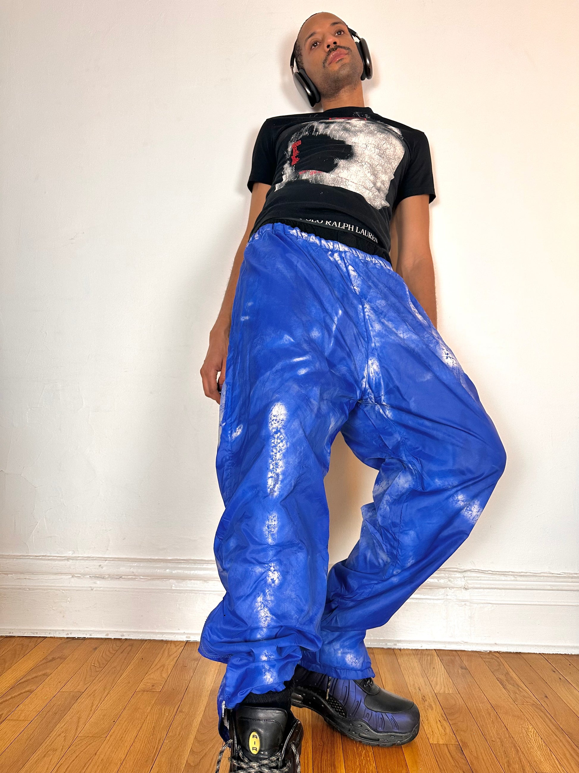 Styled image of ASTROBOI* 'Cloudy Sky' blue nylon sweatpants, XL, baggy fit, drawstring waistband, side zippers, lined for warmth, handcrafted in NYC