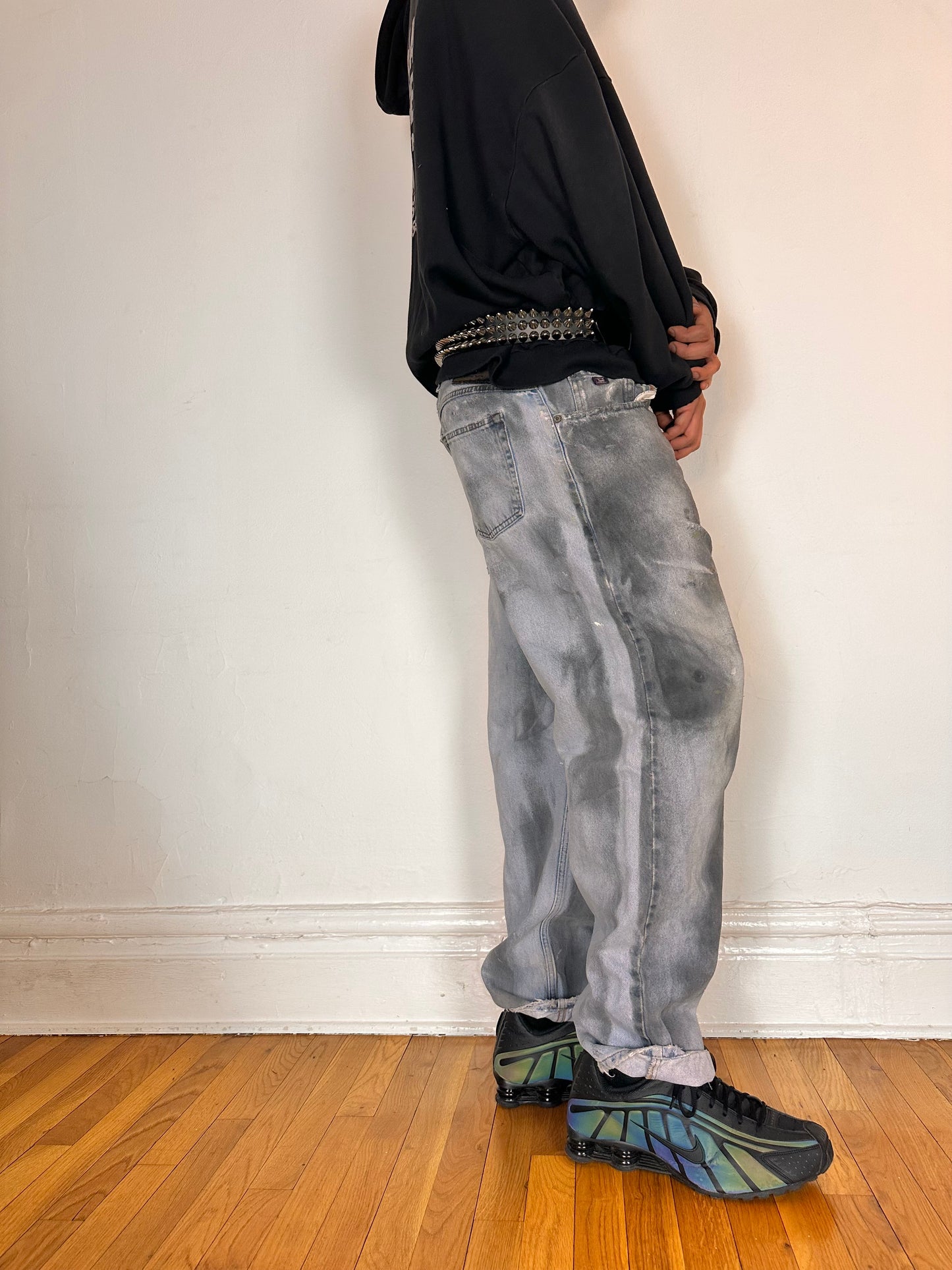 Right side of ASTROBOI* light rinse blue tar jeans with baggy fit, distressed cotton denim, and black and clay paint detailing, size 36x32