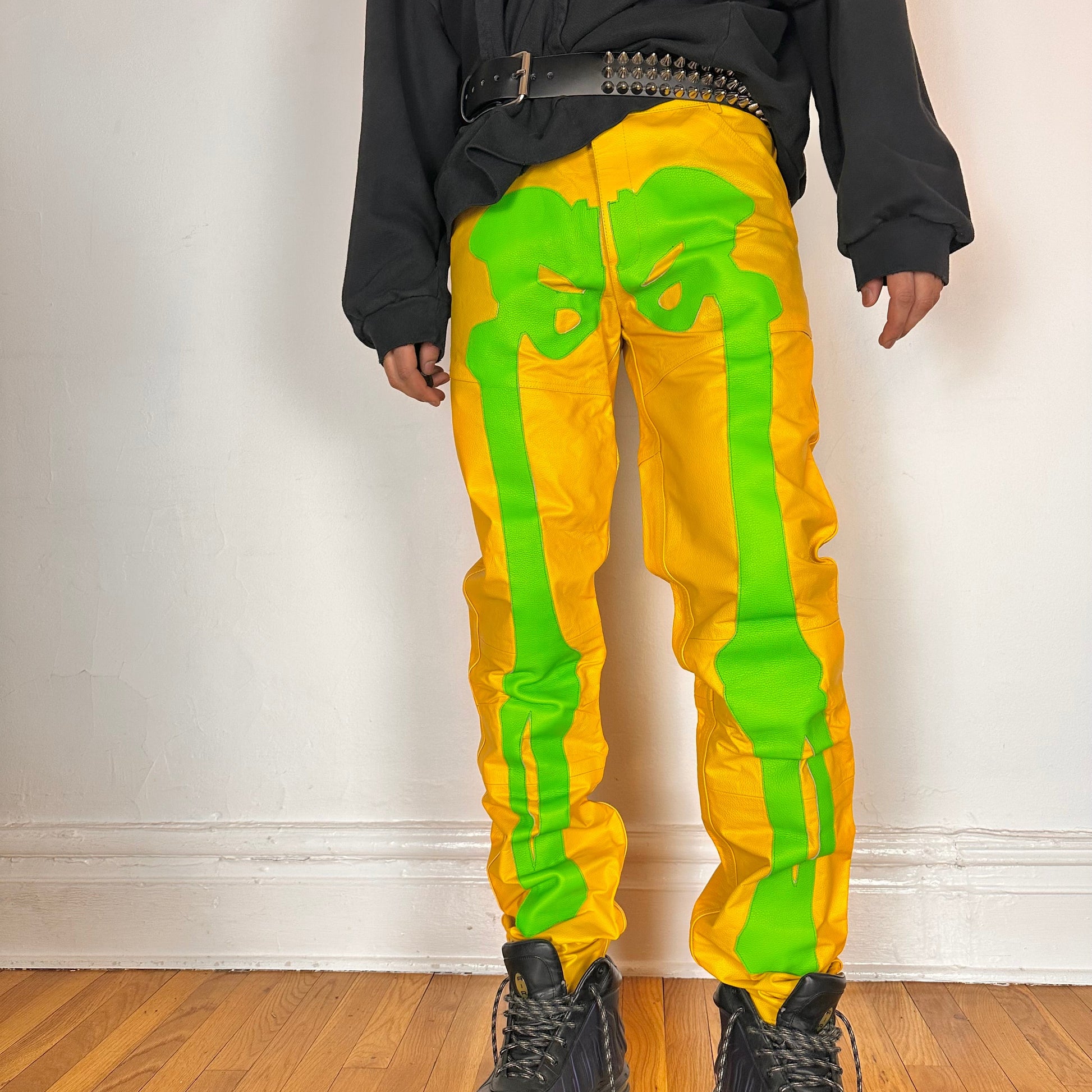 Cover image of Seeking green and yellow skeleton leather biker pants featuring a straight leg fit, bold skeleton detailing, and branded back patch. Size 36x36.