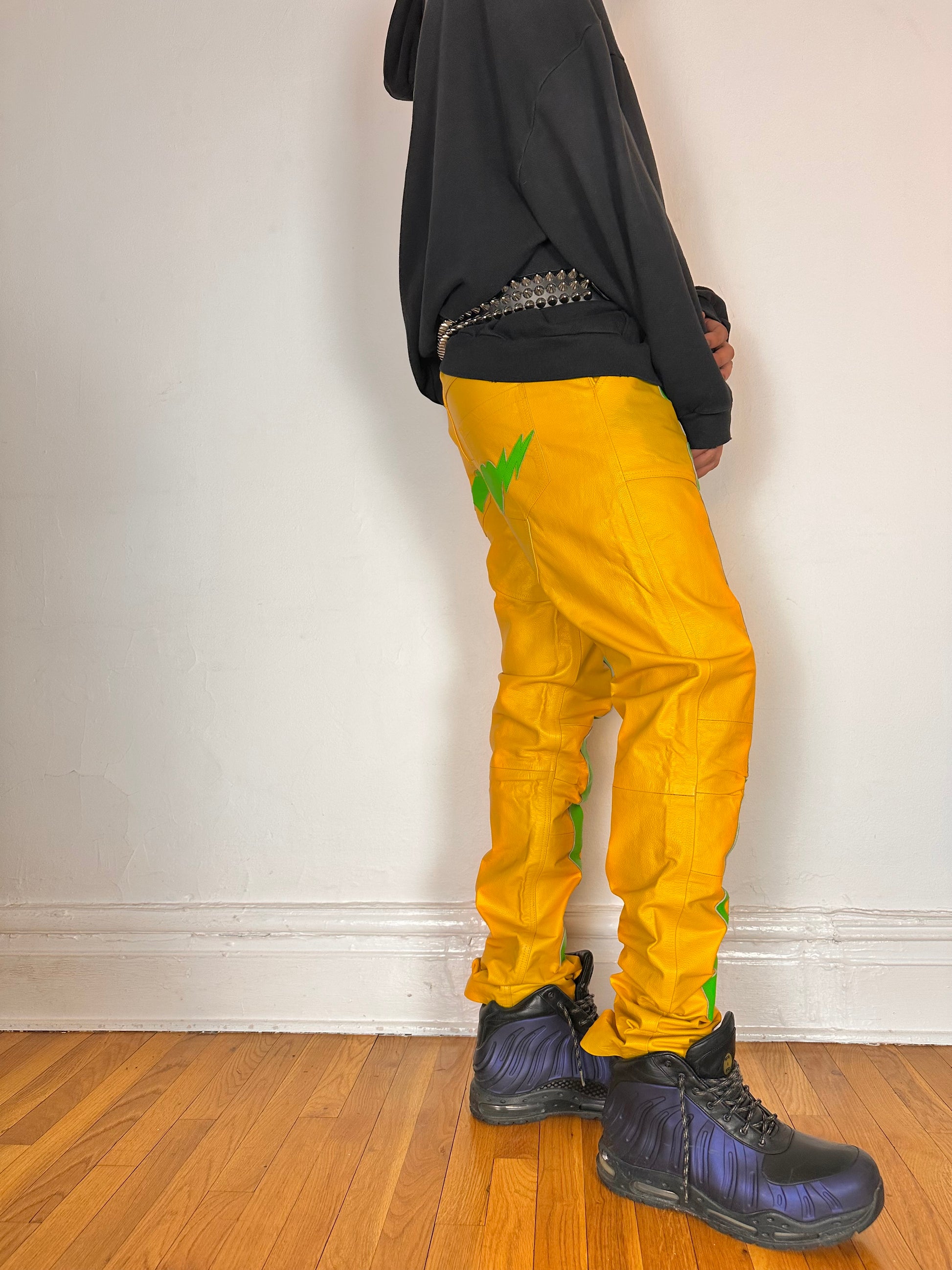 Right side of Seeking green and yellow skeleton leather biker pants featuring a straight leg fit, bold skeleton detailing, and branded back patch. Size 36x36.