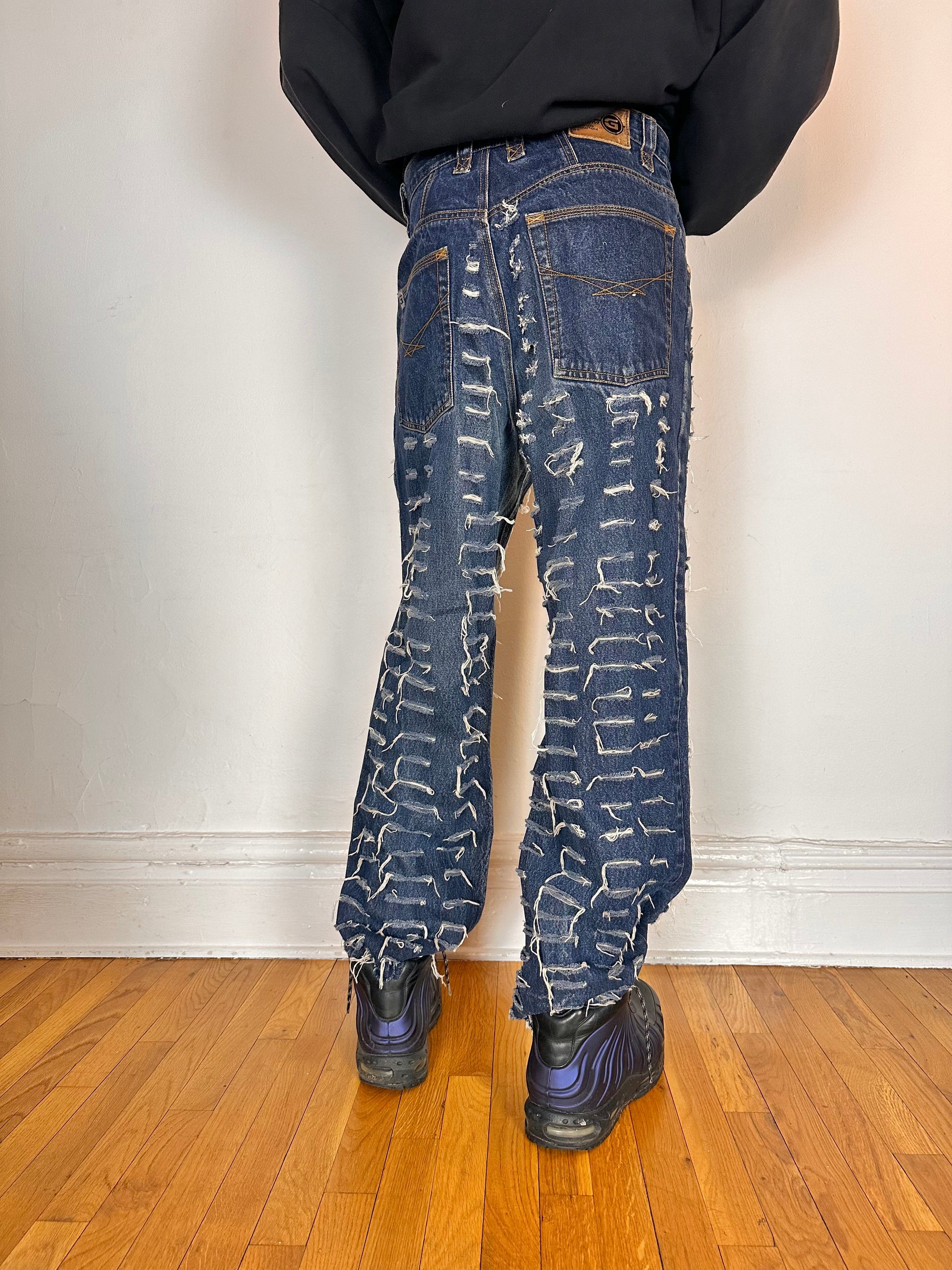 Back of ASTROBOI* blue slashed grunge faded ripped jeans with thigh and leg slashes, relaxed leg fit, size 31x34, customized in NYC