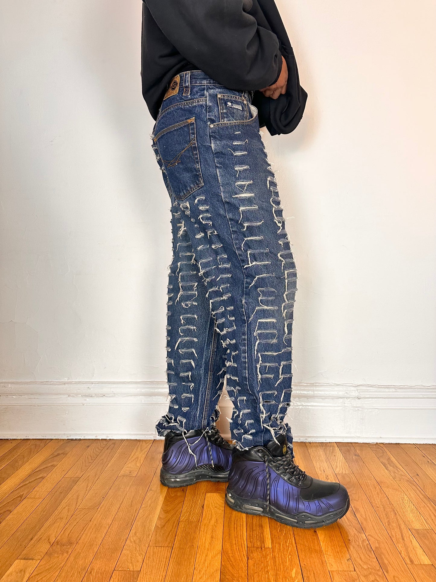 Right side of ASTROBOI* blue slashed grunge faded ripped jeans with thigh and leg slashes, relaxed leg fit, size 31x34, customized in NYC