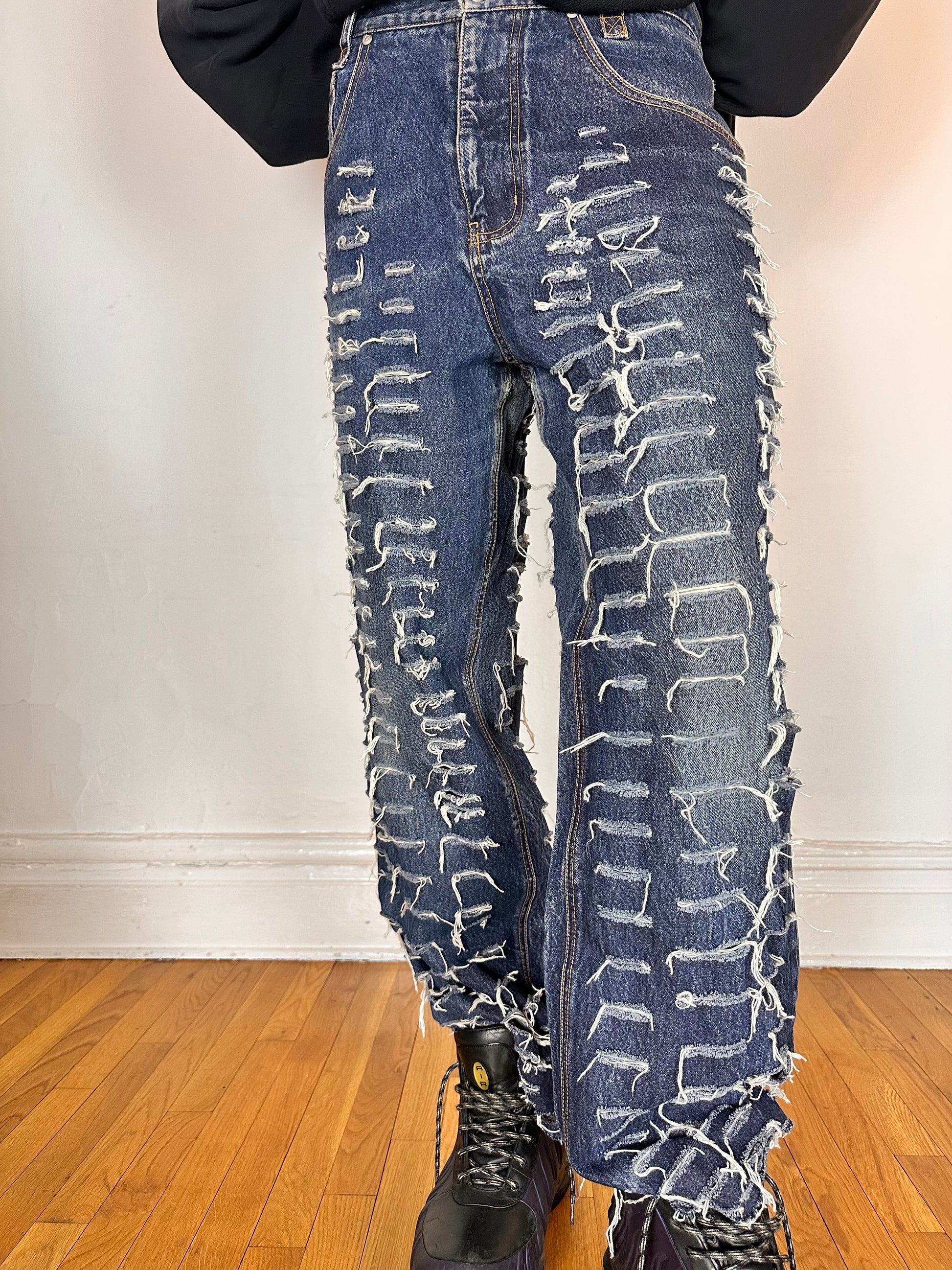 Close up of ASTROBOI* blue slashed grunge faded ripped jeans with thigh and leg slashes, relaxed leg fit, size 31x34, customized in NYC