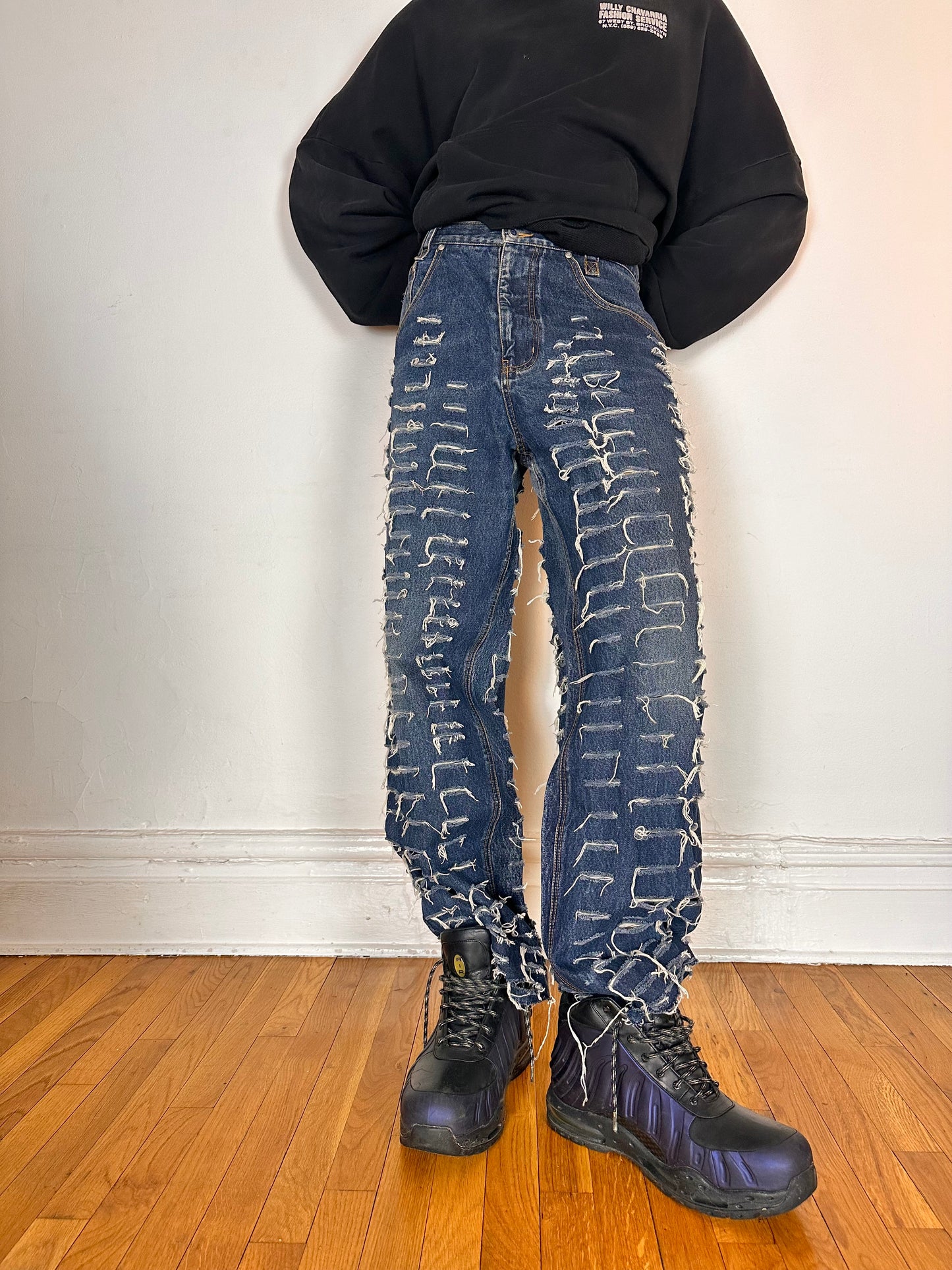 Front image of ASTROBOI* blue slashed grunge faded ripped jeans with thigh and leg slashes, relaxed leg fit, size 31x34, customized in NYC
