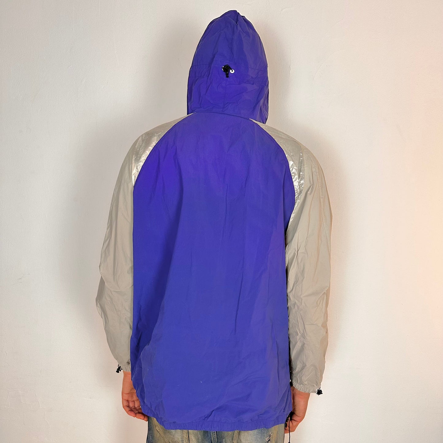 Back of ADIDAS x KOLOR purple and silver futuristic anorak windbreaker jacket with foil shoulder detailing, mesh ventilation panel, and boxy fit