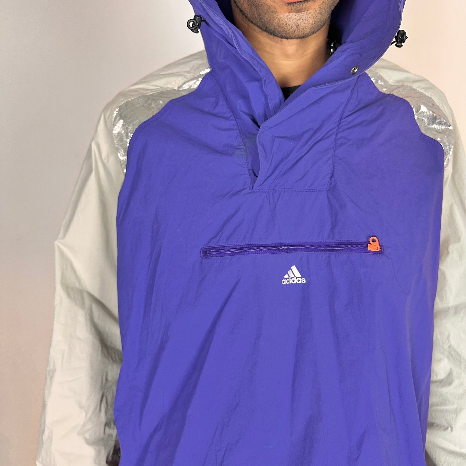 Front close up of ADIDAS x KOLOR purple and silver futuristic anorak windbreaker jacket with foil shoulder detailing, mesh ventilation panel, and boxy fit
