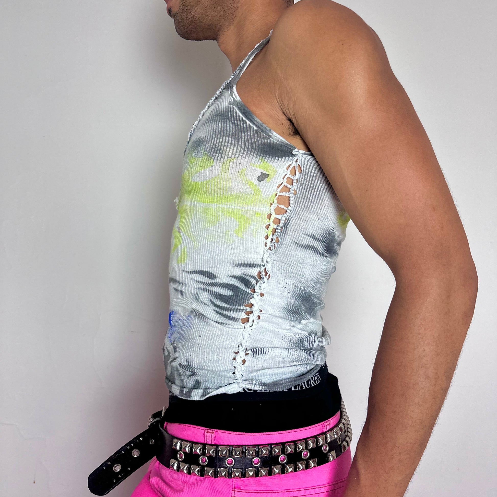 Left side detail of ASTROBOI* x Gildan 'Neon Flame' showing side braid construction and black and acid green flame print on white cotton tank.