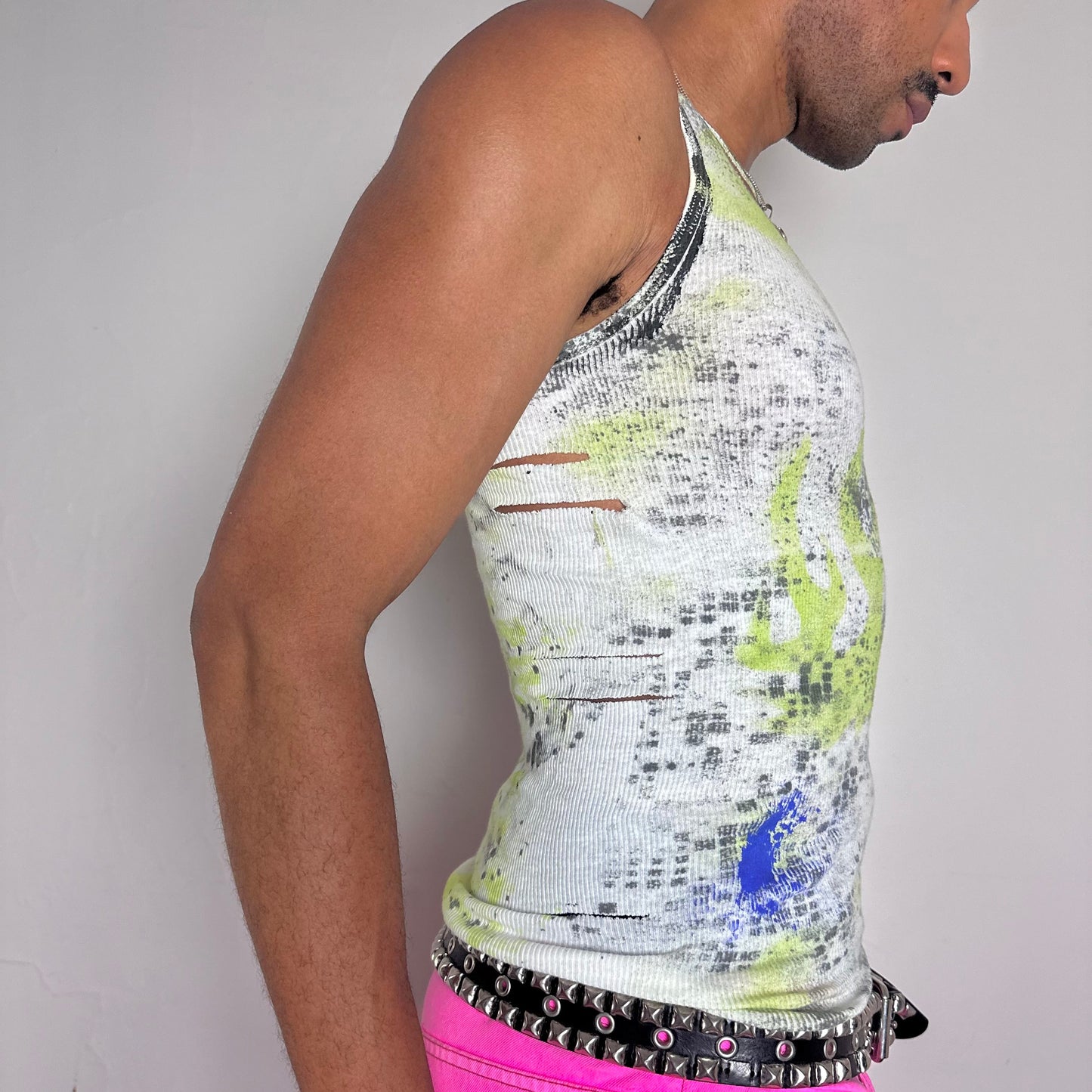 Right side detail of ASTROBOI* x Gildan 'Blitz' showing side cut-out and acid green flame print with ultraviolet splatter on white cotton base.