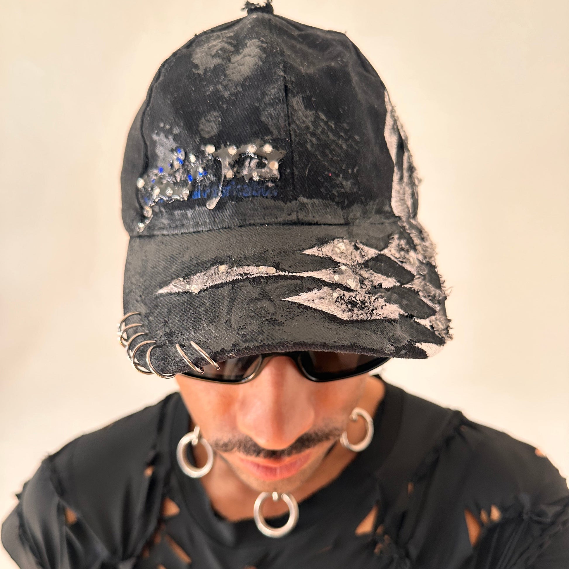 Front of ASTROBOI* Speed Racing black and white checkered utility hat with resin-set rhinestones, stainless steel piercings, and hand-painted detailing