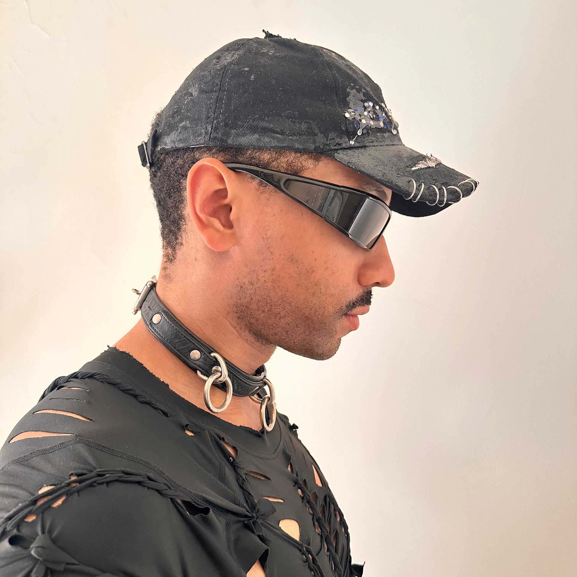 Right side of ASTROBOI* Speed Racing black and white checkered utility hat with resin-set rhinestones, stainless steel piercings, and hand-painted detailing
