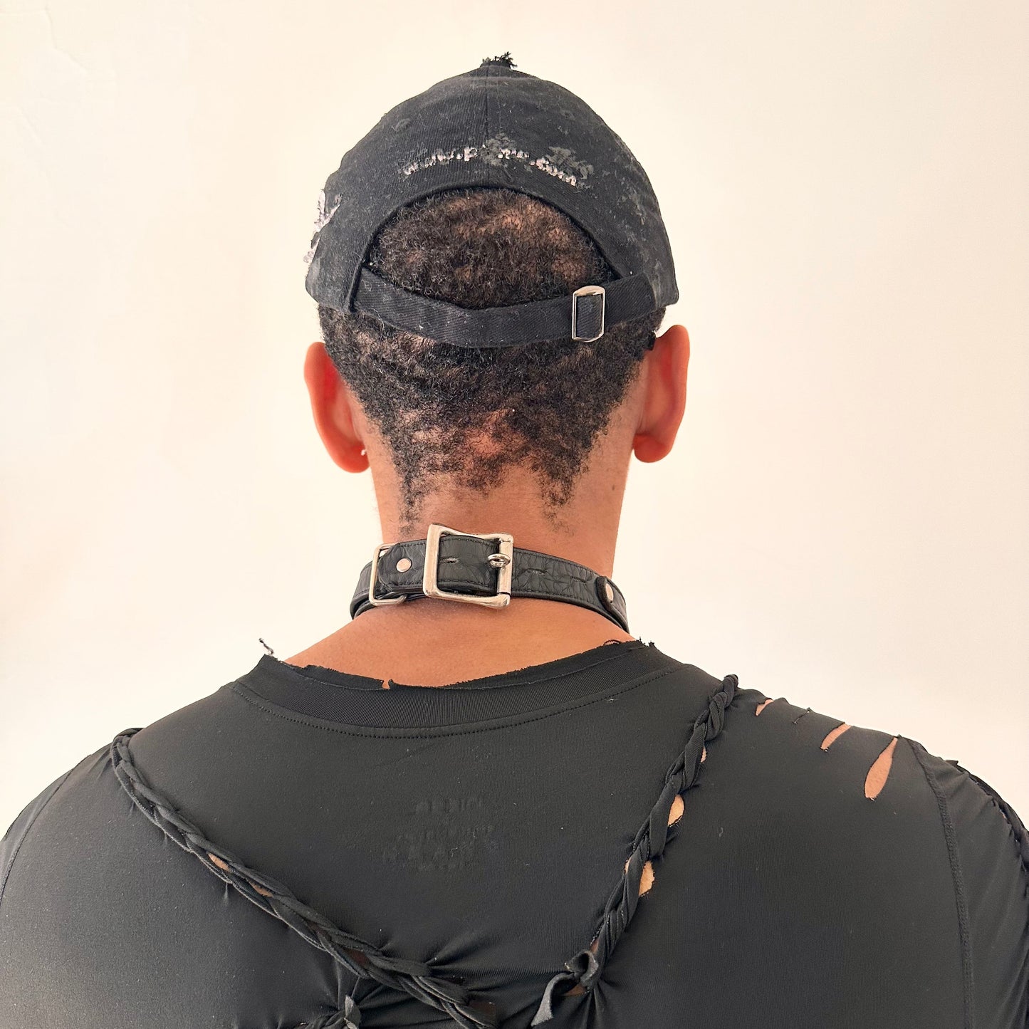 Back of of ASTROBOI* Speed Racing black and white checkered utility hat with resin-set rhinestones, stainless steel piercings, and hand-painted detailing