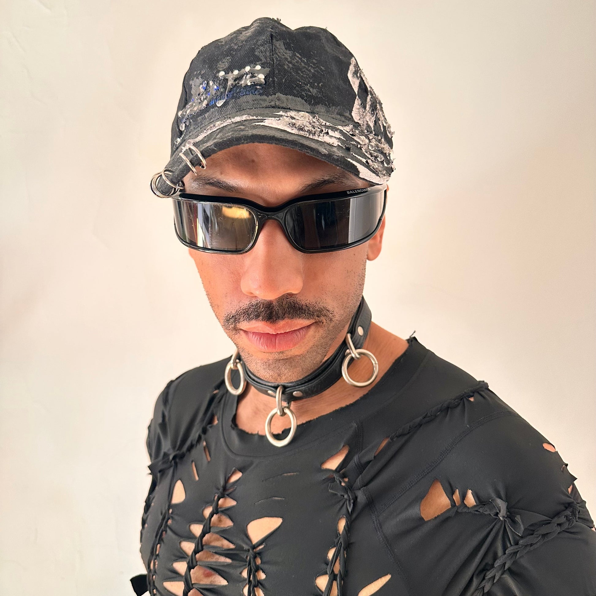 Overview of of ASTROBOI* Speed Racing black and white checkered utility hat with resin-set rhinestones, stainless steel piercings, and hand-painted detailing