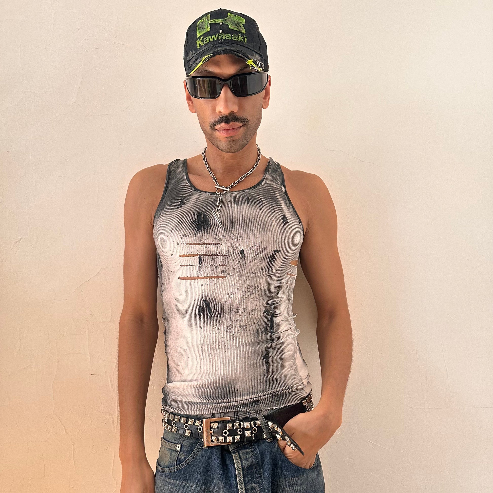 Styled image of ASTROBOI* x Hanes 'Hero' white ribbed cotton tank top with hand-painted black abstract graphic print and deconstructed cut-outs along chest and sides, customized at ASTROBOI* STUDIO in NYC.