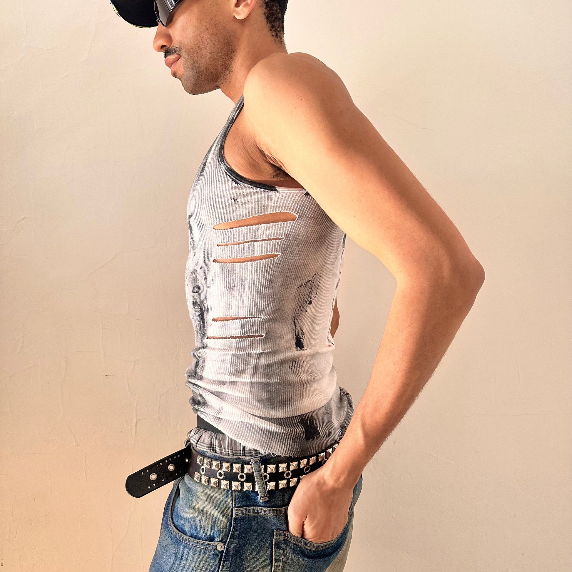 Left side of ASTROBOI* x Hanes 'Hero' white ribbed cotton tank top with hand-painted black abstract graphic print and deconstructed cut-outs along chest and sides, customized at ASTROBOI* STUDIO in NYC.