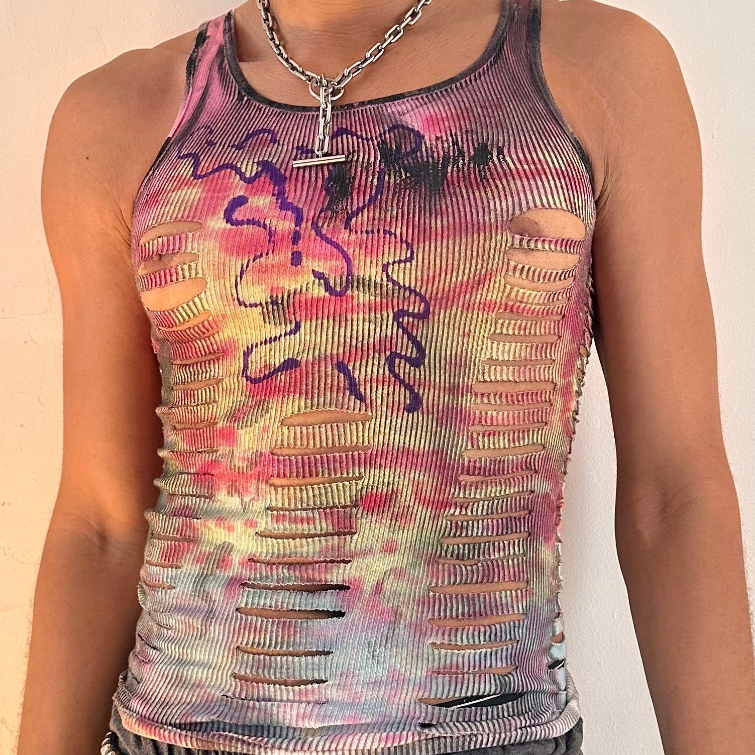 Close up of ASTROBOI* x Hanes 'Skies' tank top showing abstract purple wavy chest graphic and hand-painted tie dye detail, front view.