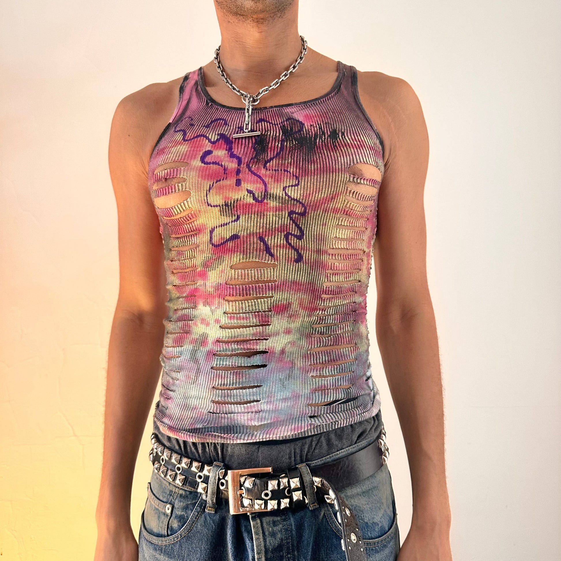 ASTROBOI* x Hanes 'Skies' slim-fit tie dye tank top with pink, yellow, blue and green fading, abstract purple chest graphic and cut-outs, worn by male model, front view.