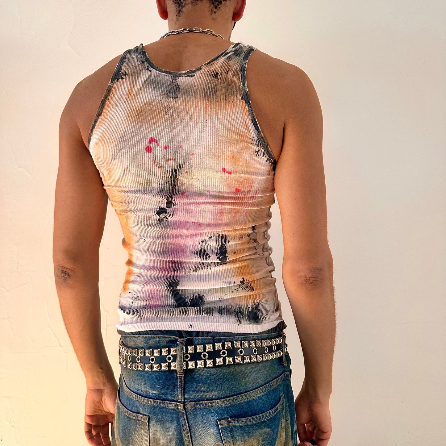 ASTROBOI* x Hanes 'HEAVEN' white ribbed graffiti tank top, rear view showing hand-painted rainbow and graffiti design, worn by male model.
